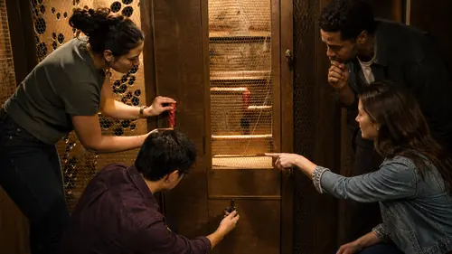 Vier Personen lösen im Escape Room in Oberkirch gemeinsam ein Rätsel an einem beleuchteten Holzschrank